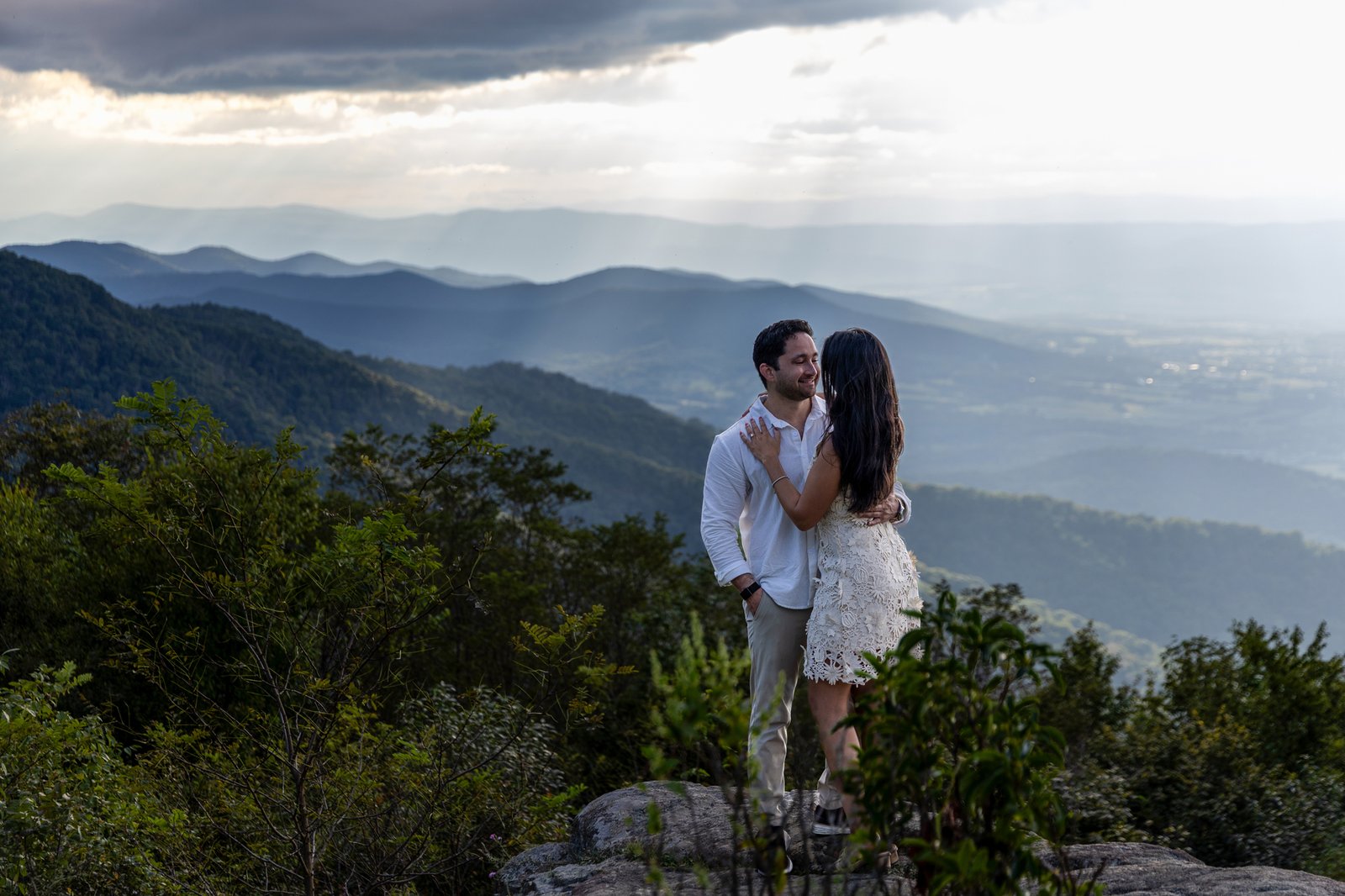  Engaged couple kissing with the engagement ring visible, Blue Ridge Mountains behind them